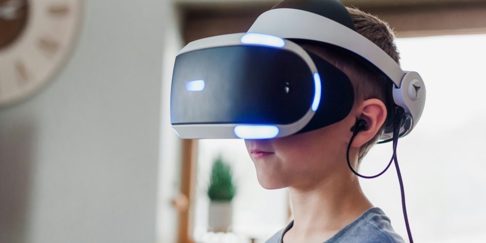 boy wearing black and white VR headset